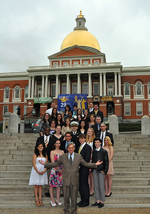 Commissioner Freeland in front of the Massachusetts State House with '29 Who shine' students.