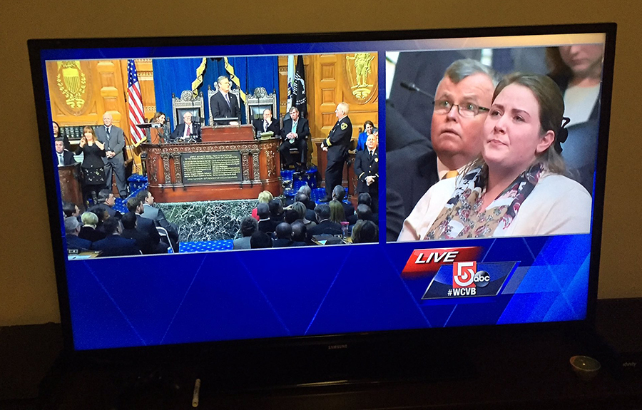 Photo of television showing a splitscreen of Governor Baker and Jaclyn King during the State of the Commonwealth address