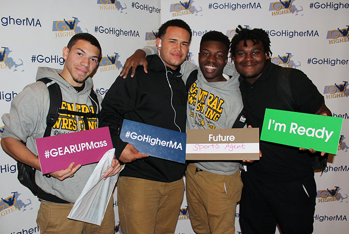 Students from Springfield High Schools pose with signs that read '#GEARUPMass' '#GoHigherMA' 'Future Sports Agent' and 'I'm Ready'