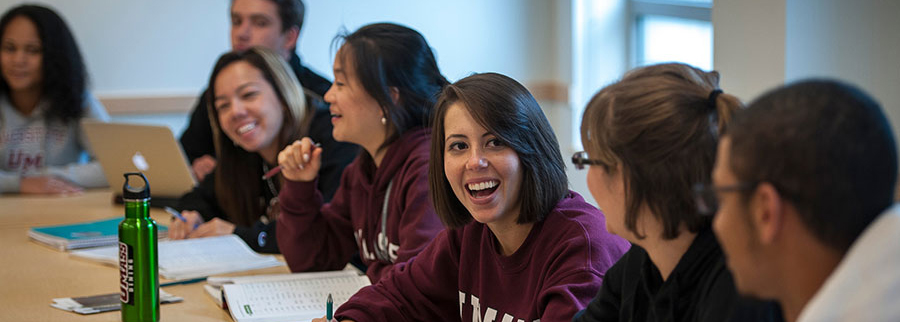 UMass Amherst students sit at a table in a classroom