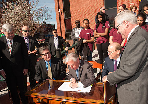 On behalf of all 25 Massachusetts public college and university presidents, (seated from left) Barry Maloney, Worcester State University; Marty Meehan, University of Massachusetts; and James Mabry, Middlesex Community College, sign the Commonwealth Commitment 
agreement, while Commissioner Santiago (right) looks on.  